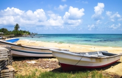Fishing boats rest on a tropical white sand beach on the Corn Islands, Nicaragua.