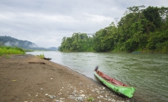 A canoe rests on the shore of the Rio Sixaola in Talamanca, Costa Rica.