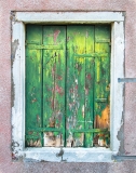 Various colors of old paint layers reveal themselves as this wooden window begins to fall apart. Venice, Italy.